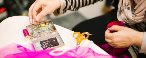 krawcowa trzymająca materiałw  kolorze madżenty