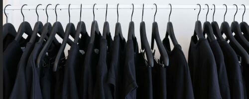 czarne garnitury ciasno zawieszone na wieszakach