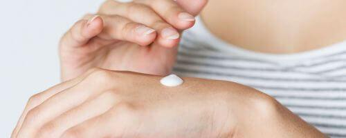 kobieca dłoń, a na niej widoczny biały krem do rąk